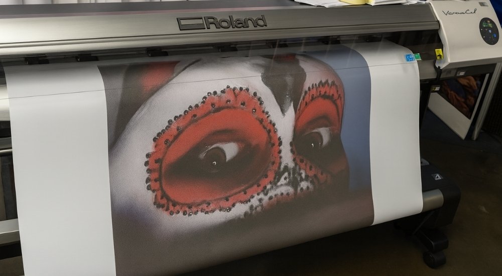 Štampa velikog formata na Roland VersaCamm printeru sa motivom lica oslikanog crvenim i belim detaljima.
