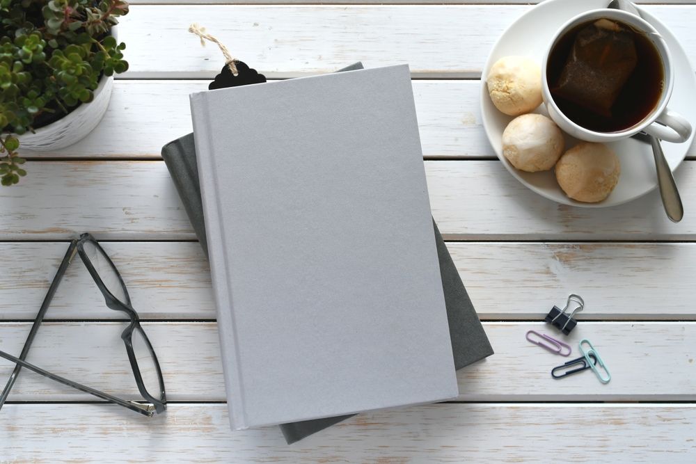 Notes, šolja kafe i kancelarijski detalji na belom drvenom stolu